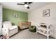 Bright Bedroom with a white glider chair, a wood crib, and a green accent wall at 4036 E Captain Dreyfus Ave, Phoenix, AZ 85032