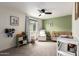 Bright Bedroom with a white glider chair, a wood crib, and a green accent wall at 4036 E Captain Dreyfus Ave, Phoenix, AZ 85032