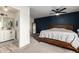 Spacious main bedroom featuring a blue accent wall, wood bed frame, and ensuite bathroom at 4036 E Captain Dreyfus Ave, Phoenix, AZ 85032