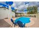 Backyard pool area with blue lounge chairs, lush greenery, and a covered patio at 4036 E Captain Dreyfus Ave, Phoenix, AZ 85032