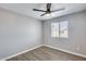 This bedroom boasts a modern ceiling fan, neutral walls and updated wood-look vinyl floors, complemented by a sunny window at 4207 W Poinsettia Dr, Phoenix, AZ 85029