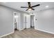 Bright bedroom leads to a bathroom and closet, featuring a modern ceiling fan and wood-look vinyl floors at 4207 W Poinsettia Dr, Phoenix, AZ 85029