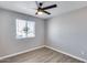 Neutral bedroom with modern ceiling fan, wood-look vinyl floors and a window with neighborhood view at 4207 W Poinsettia Dr, Phoenix, AZ 85029