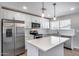 Bright kitchen features stainless steel appliances, white cabinets, stone countertops and large island at 4207 W Poinsettia Dr, Phoenix, AZ 85029