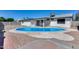 A backyard view of a bright blue pool, patio, and fenced yard at 4207 W Poinsettia Dr, Phoenix, AZ 85029
