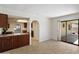 Open-concept living room with lots of natural light, slider to patio, and views into kitchen at 4257 E Marino Dr, Phoenix, AZ 85032