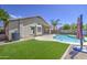 Beautiful backyard with a pool, artificial turf, covered patio, and meticulous landscaping at 4369 E Coal St, San Tan Valley, AZ 85143