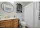 Practical bathroom featuring vanity, round mirror, cabinet storage, and clean toilet setup at 4369 E Coal St, San Tan Valley, AZ 85143