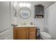Well-lit bathroom with vanity, round mirror, cabinet storage, and functional toilet setup at 4369 E Coal St, San Tan Valley, AZ 85143