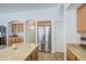 Bright kitchen view featuring a stainless steel refrigerator, arched doorways, and wood cabinetry at 4369 E Coal St, San Tan Valley, AZ 85143