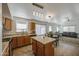 Open kitchen view featuring an island, wooden cabinets, tile flooring, and modern lighting at 4369 E Coal St, San Tan Valley, AZ 85143