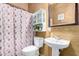 Cozy bathroom with a gingerbread-themed shower curtain, pedestal sink, and decorative mirror at 4419 W Lodge Dr, Laveen, AZ 85339