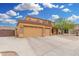 Tan two-story home with a three-car garage and low maintenance rock landscaping at 4419 W Lodge Dr, Laveen, AZ 85339