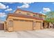 Tan two-story home with a three-car garage and low maintenance rock landscaping at 4419 W Lodge Dr, Laveen, AZ 85339