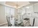 An area with a dining table features an overhead light and a kitchen with white cabinets at 4554 E Paradise Village N Pkwy # 249, Phoenix, AZ 85032