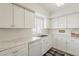Bright kitchen features white cabinetry, stainless steel sink, white appliances and light countertops at 4554 E Paradise Village N Pkwy # 249, Phoenix, AZ 85032