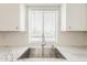 Stainless steel sink with faucet sits in front of a window; the counters are a light color at 4554 E Paradise Village N Pkwy # 249, Phoenix, AZ 85032