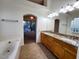 Bright bathroom featuring double sinks, a soaking tub, and large mirror at 4643 N Clear Creek Dr, Litchfield Park, AZ 85340