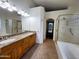 Bathroom with double sinks, granite countertops, separate tub, and glass door shower at 4643 N Clear Creek Dr, Litchfield Park, AZ 85340