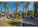 Gated community entrance with lush landscaping, mature palm trees and well kept grass at 4643 N Clear Creek Dr, Litchfield Park, AZ 85340
