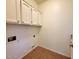Utility room featuring upper cabinets, tile flooring, and washer/dryer hookups at 4643 N Clear Creek Dr, Litchfield Park, AZ 85340