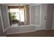 Bedroom with tile flooring, white door, and louvered windows that let in natural light at 4773 E Hopi St, Phoenix, AZ 85044