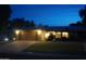 Inviting single-story home with manicured lawn, mature trees, and a two-car garage, illuminated at twilight at 4773 E Hopi St, Phoenix, AZ 85044