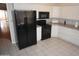 Well-lit kitchen featuring white cabinets and black appliances at 4773 E Hopi St, Phoenix, AZ 85044