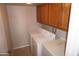 Functional laundry room includes washer, dryer, upper cabinets, and counter space at 4773 E Hopi St, Phoenix, AZ 85044
