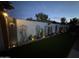 Backyard landscape lighting on the wall, turf lawn and decorative plants for evening enjoyment at 5361 N 77Th Ln, Glendale, AZ 85303