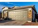 A close up of the two car garage showing brick detail and neutral color palette at 5361 N 77Th Ln, Glendale, AZ 85303