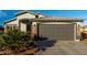 Front exterior view of the attached two car garage and desert landscaping at 5361 N 77Th Ln, Glendale, AZ 85303