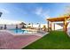 Attractive backyard featuring a pool, lounge area, pergola, and well-maintained synthetic grass at 5361 N 77Th Ln, Glendale, AZ 85303