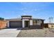 Inviting single-story home featuring a gray garage door, stone accents, and a well-maintained gravel yard at 5875 N 193Rd Dr, Litchfield Park, AZ 85340
