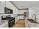 Modern kitchen featuring stainless steel appliances, white cabinets, and granite countertops at 5875 N 193Rd Dr, Litchfield Park, AZ 85340