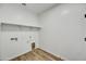 This laundry room has white walls, wood-look floors, and includes connections for your washer and dryer at 5875 N 193Rd Dr, Litchfield Park, AZ 85340