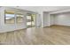 Bright room with hardwood-style tile floors, windows, and sliding glass doors to the covered patio at 5875 N 193Rd Dr, Litchfield Park, AZ 85340