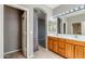 Bathroom boasts double sinks, wood cabinets, tile floors and framed mirrors at 6615 S 25Th Dr, Phoenix, AZ 85041