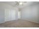Bedroom with neutral carpet, white walls, ceiling fan, and closet at 6615 S 25Th Dr, Phoenix, AZ 85041