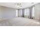 Spacious bedroom with a ceiling fan, large windows, and neutral carpet at 6615 S 25Th Dr, Phoenix, AZ 85041