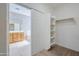 Walk-in closet with built-in shelving and a view to the bathroom at 6615 S 25Th Dr, Phoenix, AZ 85041