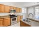 Attractive kitchen with stainless steel appliances, granite countertops, and oak cabinetry at 6615 S 25Th Dr, Phoenix, AZ 85041