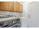 Laundry room with wood cabinets and modern washer and dryer units at 6615 S 25Th Dr, Phoenix, AZ 85041