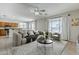 Staged living space with neutral tones, a plush sofa, and seamless transition into the adjacent kitchen at 6615 S 25Th Dr, Phoenix, AZ 85041