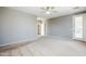 Bright main bedroom featuring carpet flooring, ceiling fan, and ample natural light at 6615 S 25Th Dr, Phoenix, AZ 85041