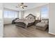 Comfortable main bedroom featuring hardwood floors, a ceiling fan, windows and a decorative bed at 7628 W Donald Dr, Peoria, AZ 85383