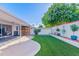 Relaxing backyard featuring artificial grass, covered patio, and privacy wall, ideal for outdoor living and entertaining at 7732 E Coolidge St, Scottsdale, AZ 85251