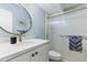 Bright bathroom featuring a modern vanity, round mirror, and glass-enclosed shower, creating a clean and stylish space at 7732 E Coolidge St, Scottsdale, AZ 85251