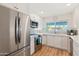 Well-lit kitchen with stainless steel appliances, white cabinets, and a view to the backyard at 7732 E Coolidge St, Scottsdale, AZ 85251