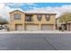 Two-story townhome featuring three garage spaces with neutral paint and desert landscaping at 8105 W Groom Creek Rd, Phoenix, AZ 85043